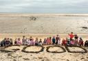 Good school: Pupils on the beach celebrating the result