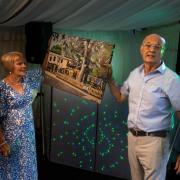 Lesley and Les Talbot with the large canvas painting they were gifted at the anniversary.