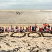 Good school: Pupils on the beach celebrating the result